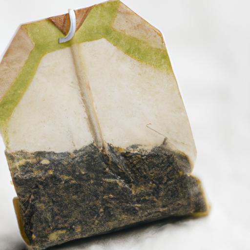 A close-up photo of a green tea bag steeping in hot water
